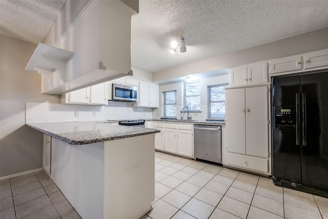 kitchen featuring light tile patterned floors, appliances with stainless steel finishes, kitchen peninsula, decorative backsplash, and white cabinets