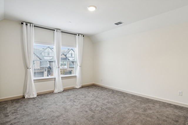 carpeted empty room with lofted ceiling