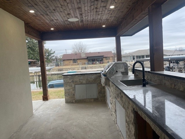 view of patio with a water view, area for grilling, and sink