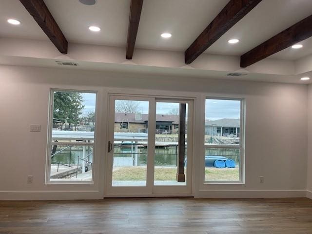 doorway featuring wood-type flooring, beamed ceiling, and a water view