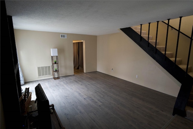 unfurnished living room featuring hardwood / wood-style floors and a textured ceiling