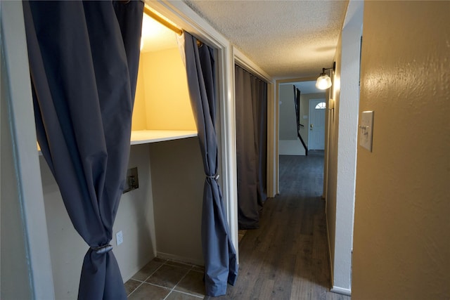 corridor featuring dark hardwood / wood-style floors and a textured ceiling