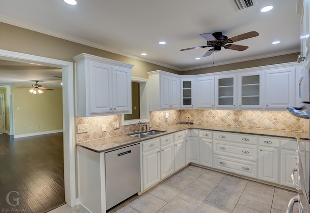 kitchen with dark stone countertops, sink, stainless steel dishwasher, and white cabinets