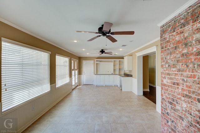 unfurnished living room with crown molding, brick wall, and light tile patterned floors