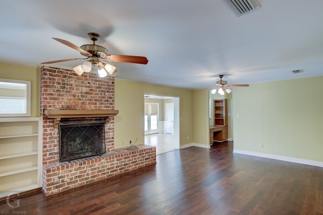 unfurnished living room featuring ceiling fan, ornamental molding, dark wood-type flooring, and a fireplace