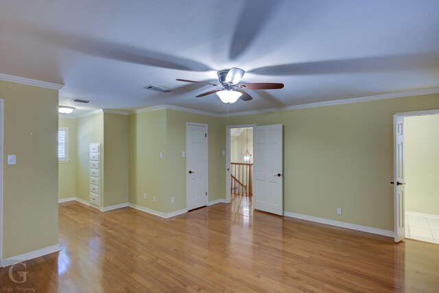 empty room with ornamental molding, ceiling fan, and light hardwood / wood-style flooring