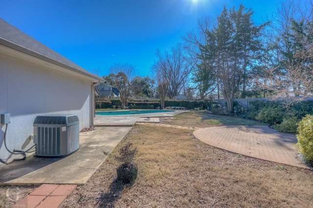 view of pool with a lawn, a patio area, and central air condition unit