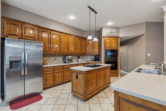 kitchen with sink, tasteful backsplash, hanging light fixtures, a kitchen island with sink, and black appliances