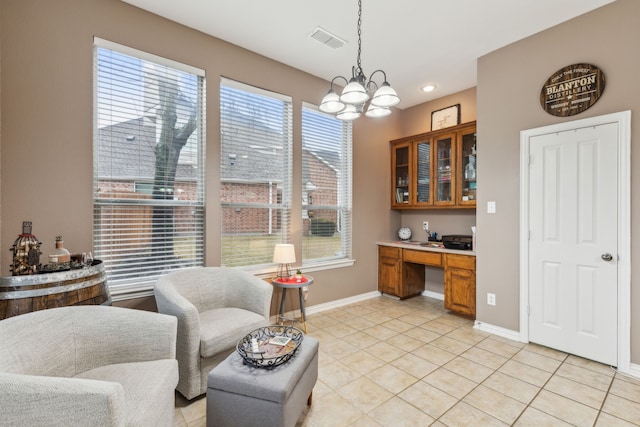 sitting room with light tile patterned floors, a notable chandelier, and built in desk