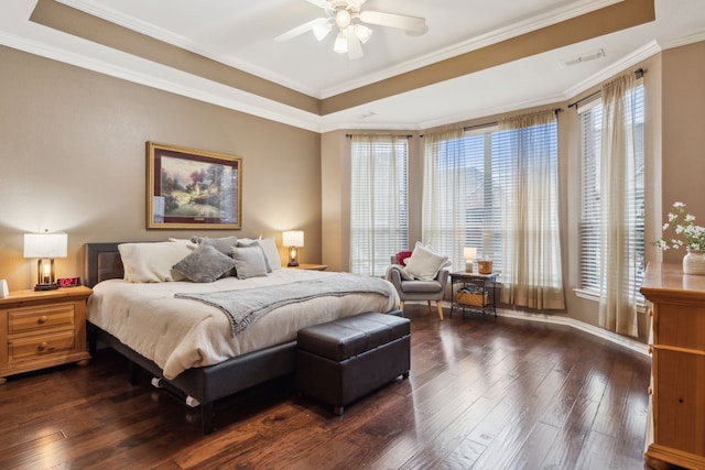 bedroom with a raised ceiling, crown molding, and dark hardwood / wood-style flooring