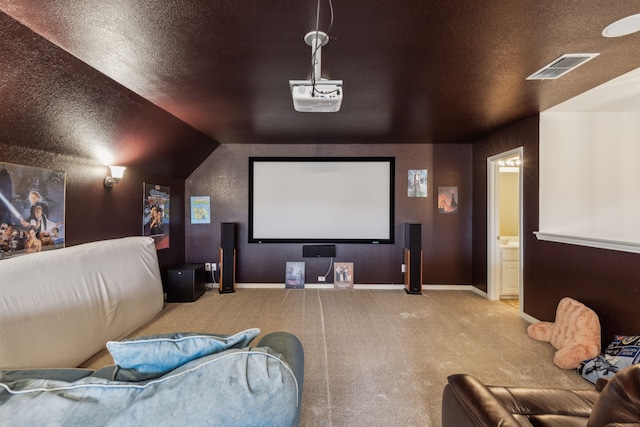 carpeted home theater featuring vaulted ceiling and a textured ceiling