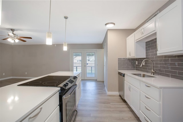 kitchen featuring sink, white cabinetry, backsplash, stainless steel appliances, and french doors