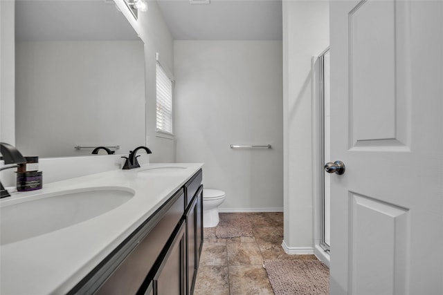 bathroom with vanity, toilet, and a shower with door