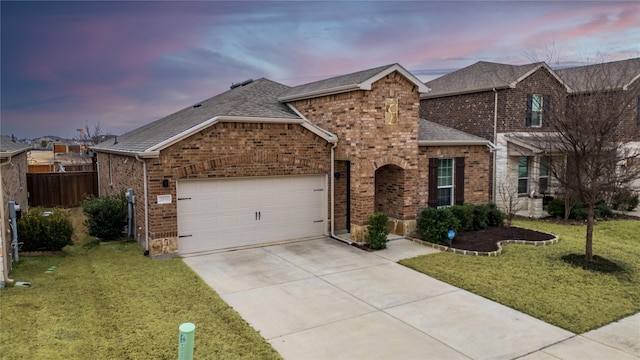 view of front of home with a garage and a yard