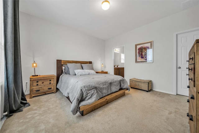 bedroom with light colored carpet and ensuite bathroom