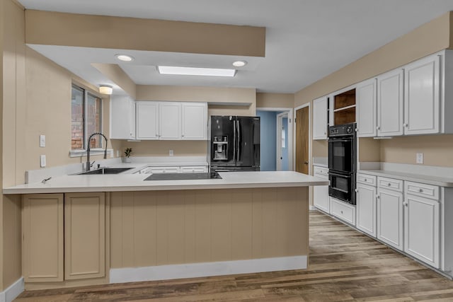 kitchen featuring white cabinetry, sink, kitchen peninsula, and black appliances