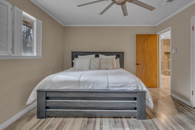 bedroom with ornamental molding, ceiling fan, and light wood-type flooring