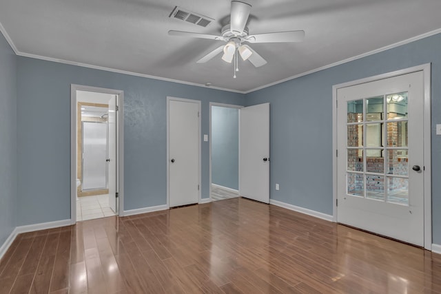 unfurnished bedroom featuring hardwood / wood-style floors, crown molding, and ensuite bathroom