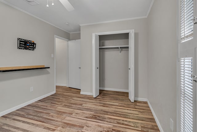 unfurnished bedroom featuring crown molding, a closet, ceiling fan, and light hardwood / wood-style flooring