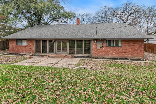 rear view of property with a patio and a lawn