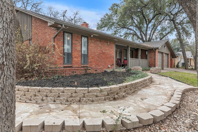 view of side of home featuring a garage and covered porch