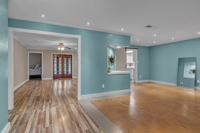 unfurnished living room featuring ceiling fan, ornamental molding, french doors, a barn door, and light wood-type flooring