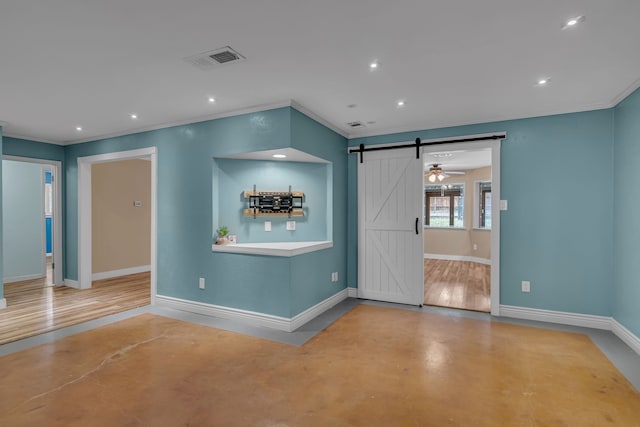 interior space with ornamental molding, concrete flooring, and a barn door