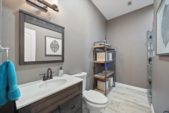 bathroom with vanity, hardwood / wood-style floors, and toilet