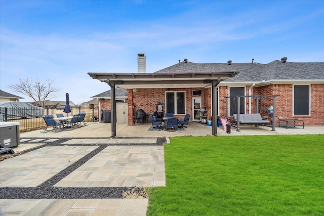 back of property with a patio and a lawn