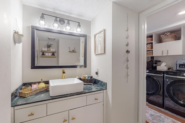 bathroom featuring vanity, independent washer and dryer, and a textured ceiling