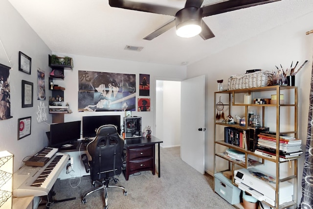 carpeted home office featuring ceiling fan