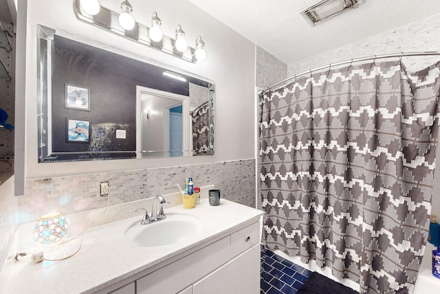 bathroom featuring vanity, a textured ceiling, and tile walls