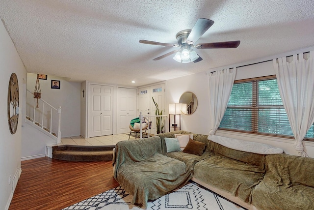 living room with ceiling fan, wood-type flooring, and a textured ceiling