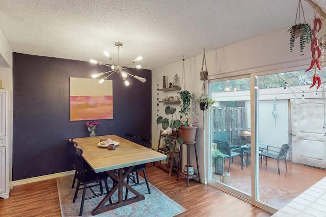 dining area with an inviting chandelier, hardwood / wood-style flooring, and a textured ceiling