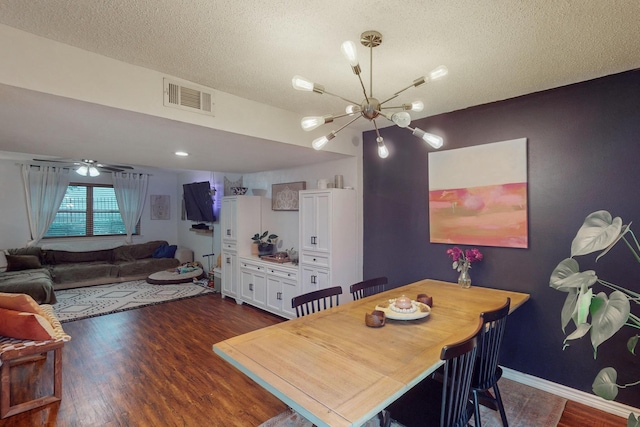 dining space featuring an inviting chandelier, a textured ceiling, and dark hardwood / wood-style flooring