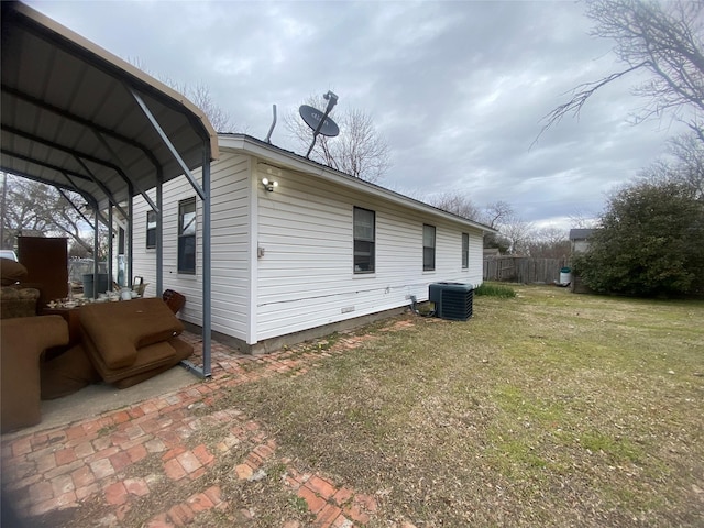 view of property exterior featuring a carport, a yard, and cooling unit