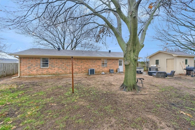 rear view of house featuring cooling unit and an outdoor structure