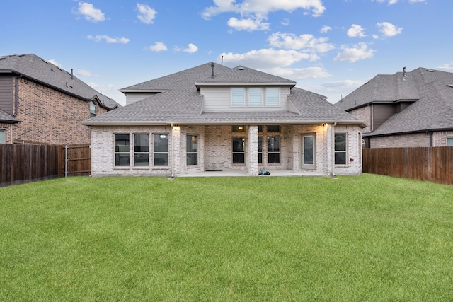 rear view of property featuring a yard and a patio area