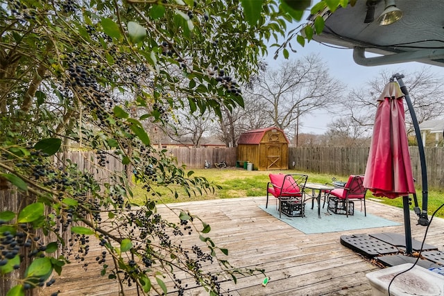 deck featuring a storage unit and a yard