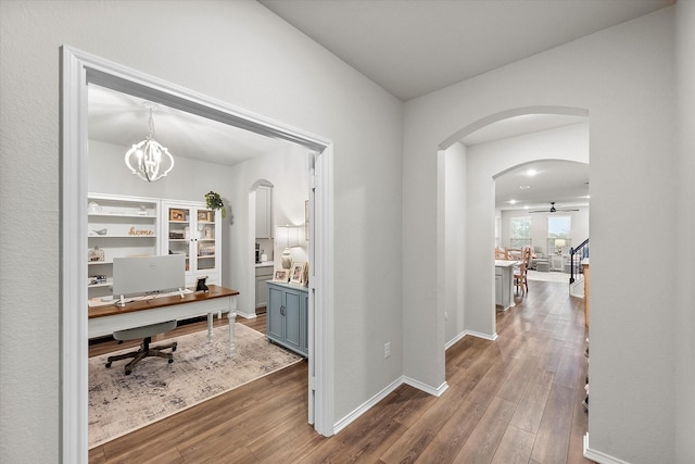 corridor featuring a notable chandelier and dark hardwood / wood-style floors