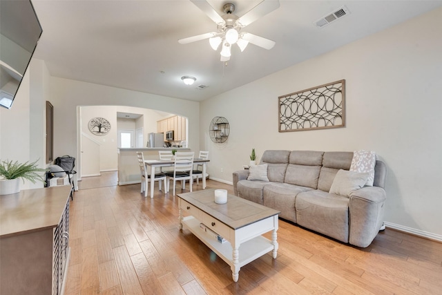 living room featuring ceiling fan and light hardwood / wood-style floors