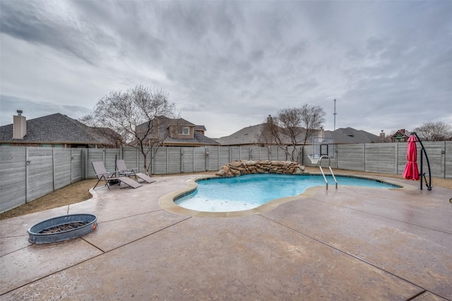 view of swimming pool with an outdoor fire pit and a patio