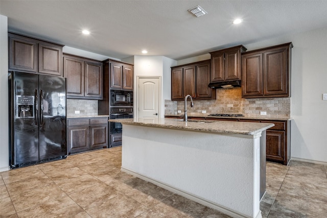 kitchen featuring an island with sink, sink, dark brown cabinetry, and black appliances