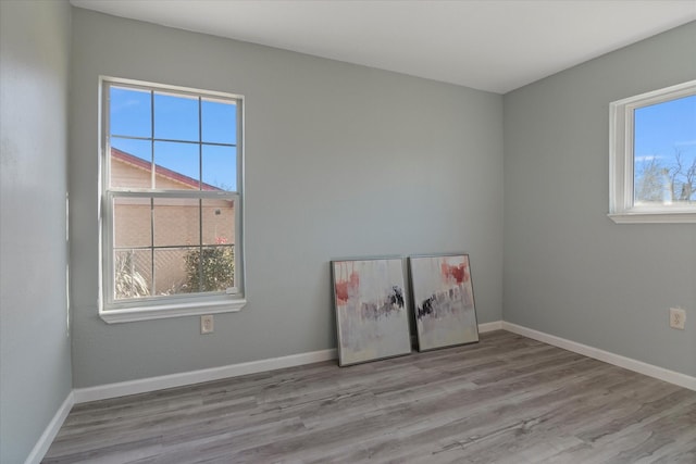 spare room with a healthy amount of sunlight and light hardwood / wood-style flooring