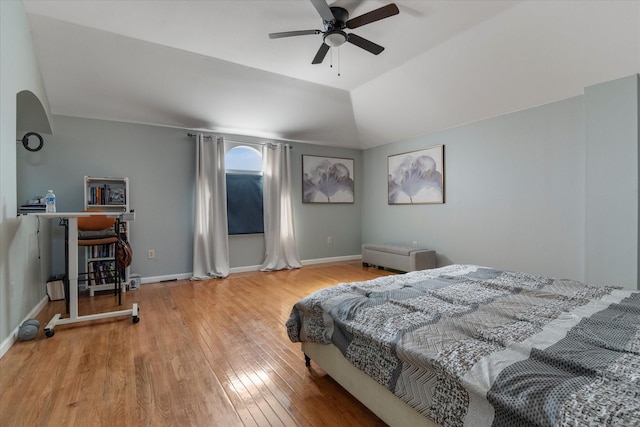 bedroom with hardwood / wood-style flooring, vaulted ceiling, and ceiling fan