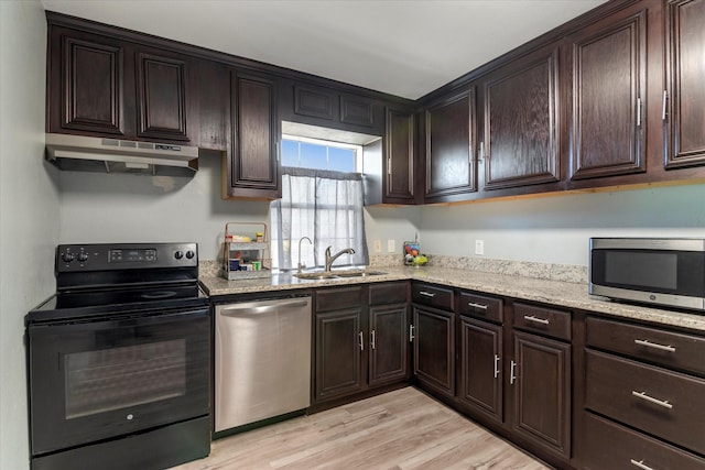 kitchen featuring appliances with stainless steel finishes, sink, light stone counters, light hardwood / wood-style floors, and dark brown cabinets