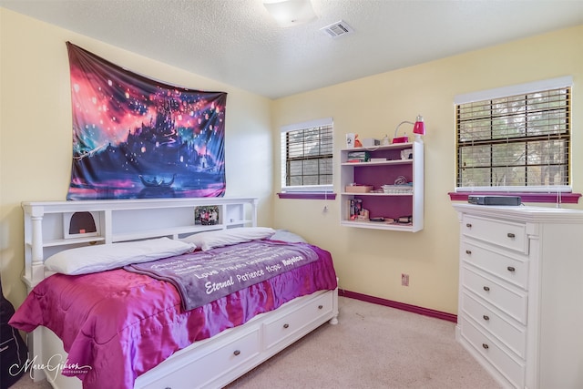 bedroom with light carpet and a textured ceiling