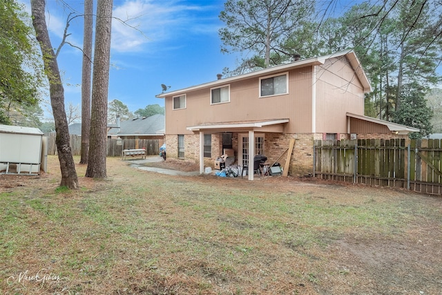 rear view of house with a yard and a storage shed