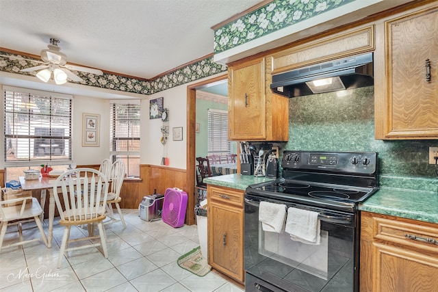 kitchen with a textured ceiling, light tile patterned floors, ceiling fan, black range with electric stovetop, and range hood