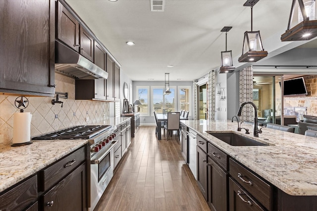 kitchen with appliances with stainless steel finishes, decorative light fixtures, sink, and decorative backsplash